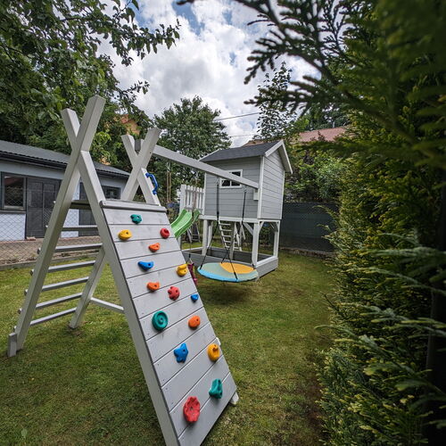 Plac zabaw.Domek ,zjezdzalnia ,hustawki ścianka wspinaczkowa i piaskownica