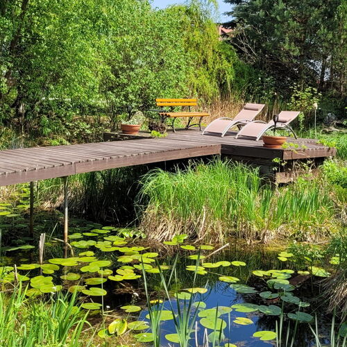 Staw z wyspą i wodospadem w Kamiennym Ogrodzie Holiday Park