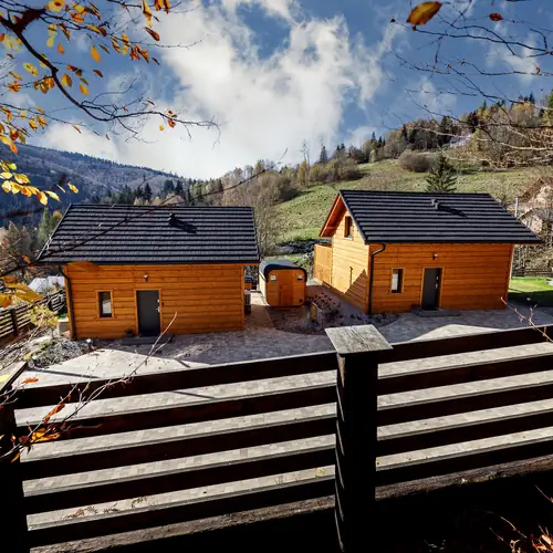 dwa identyczne sześcioosobowe domki, pomiędzy domkami sauna 