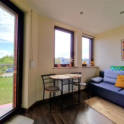 Pok&oacute;j z rozkładaną sofą, wyjściem na taras, TV i w pełni wyposażonym aneksem kuchennym