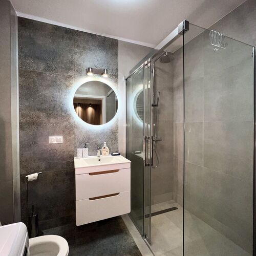 Łazienka z dużym prysznicem oraz pralką