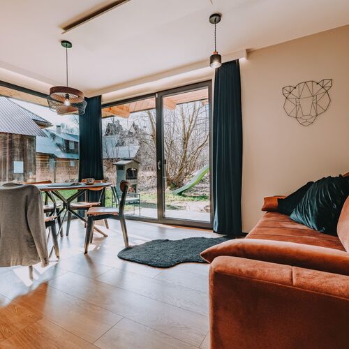 Niezwykłym atutem tego pomieszczenia są duże okna pełniące funkcję drzwi, przez kt&oacute;re można wyjść na taras i do ogrodu. Dzięki 