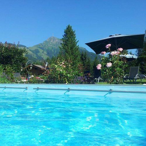 beheiztes Pool mit Parnoama Schiebehalle mit Blick auf das Kitzbüheler Horn und den Wilden Kaiser