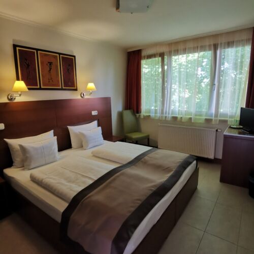 Pokoj s manželskou postelí s výhledem do dvora na poschodí