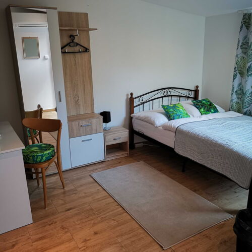 Pokoj s manželskou postelí a jedním samostatným lužkem