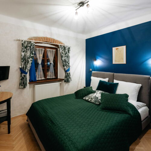 Pokoj se sprchou s manželskou postelí na poschodí