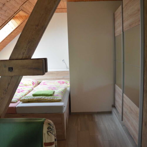 Pokoj se sprchou s manželskou postelí v podkroví