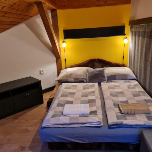 Pokoj se sprchou s manželskou postelí v podkroví